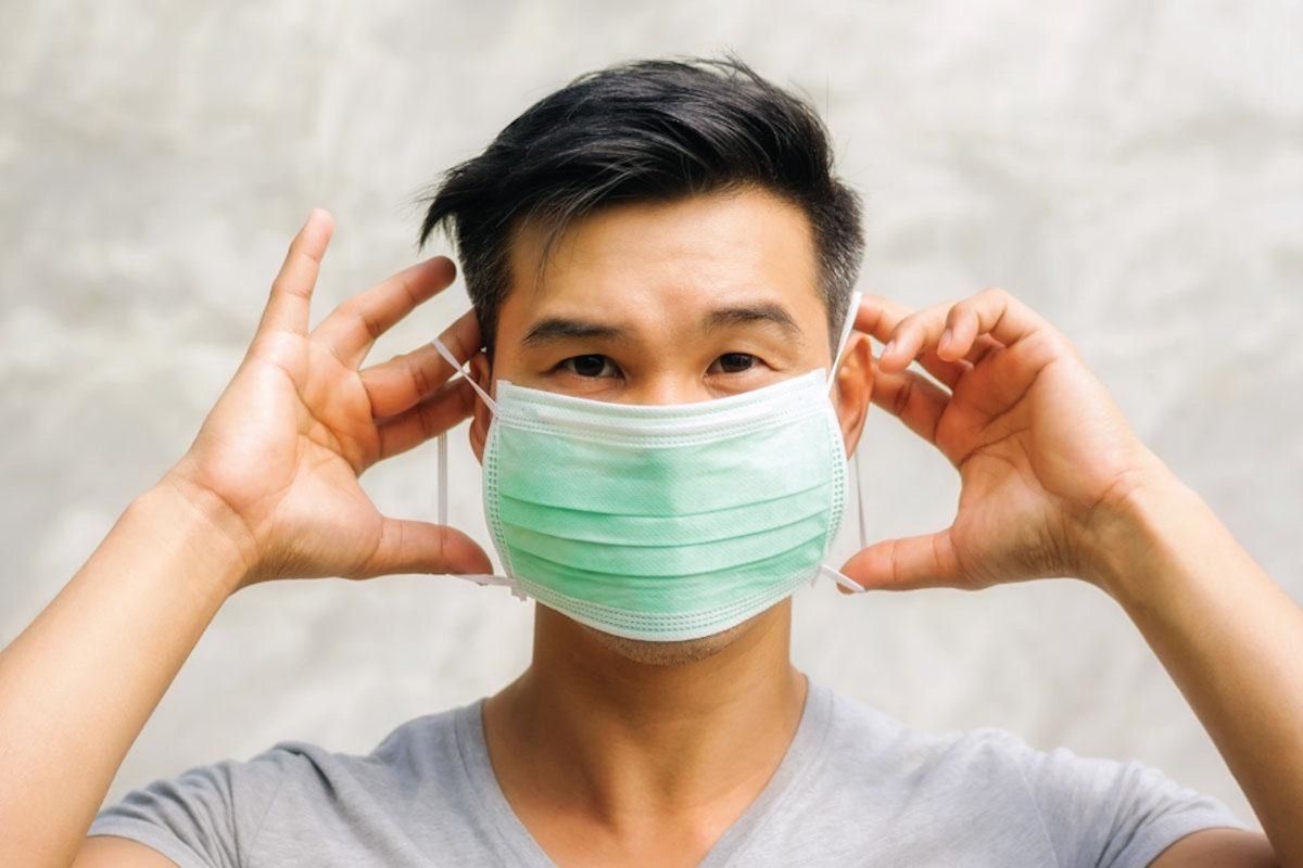 man-putting-on-a-surgical-mask.jpg